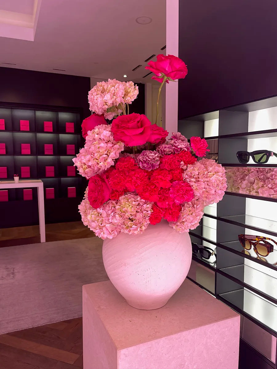 Pink-red flowers in white vase, boutique style