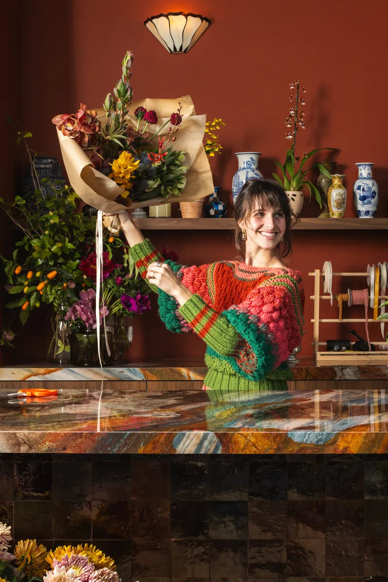 Florist in colorful sweater holding bouquet