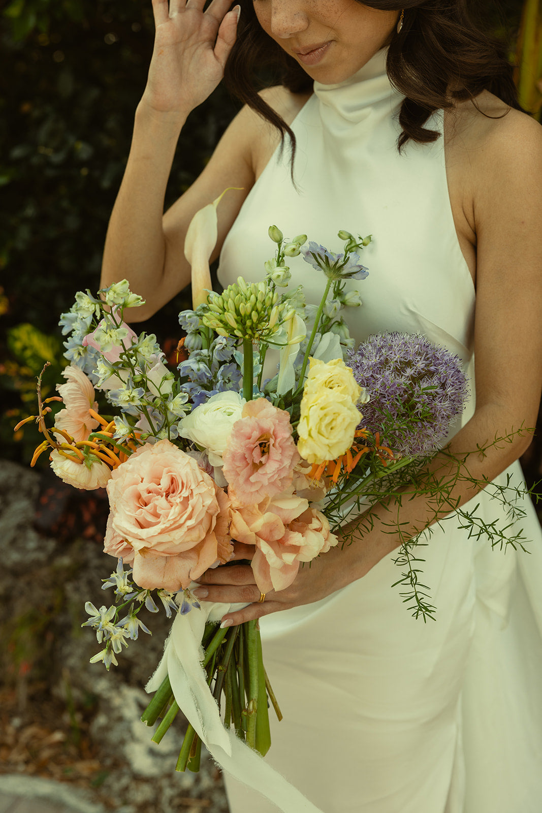 Bride holds pastel bouquet with roses and greenery
