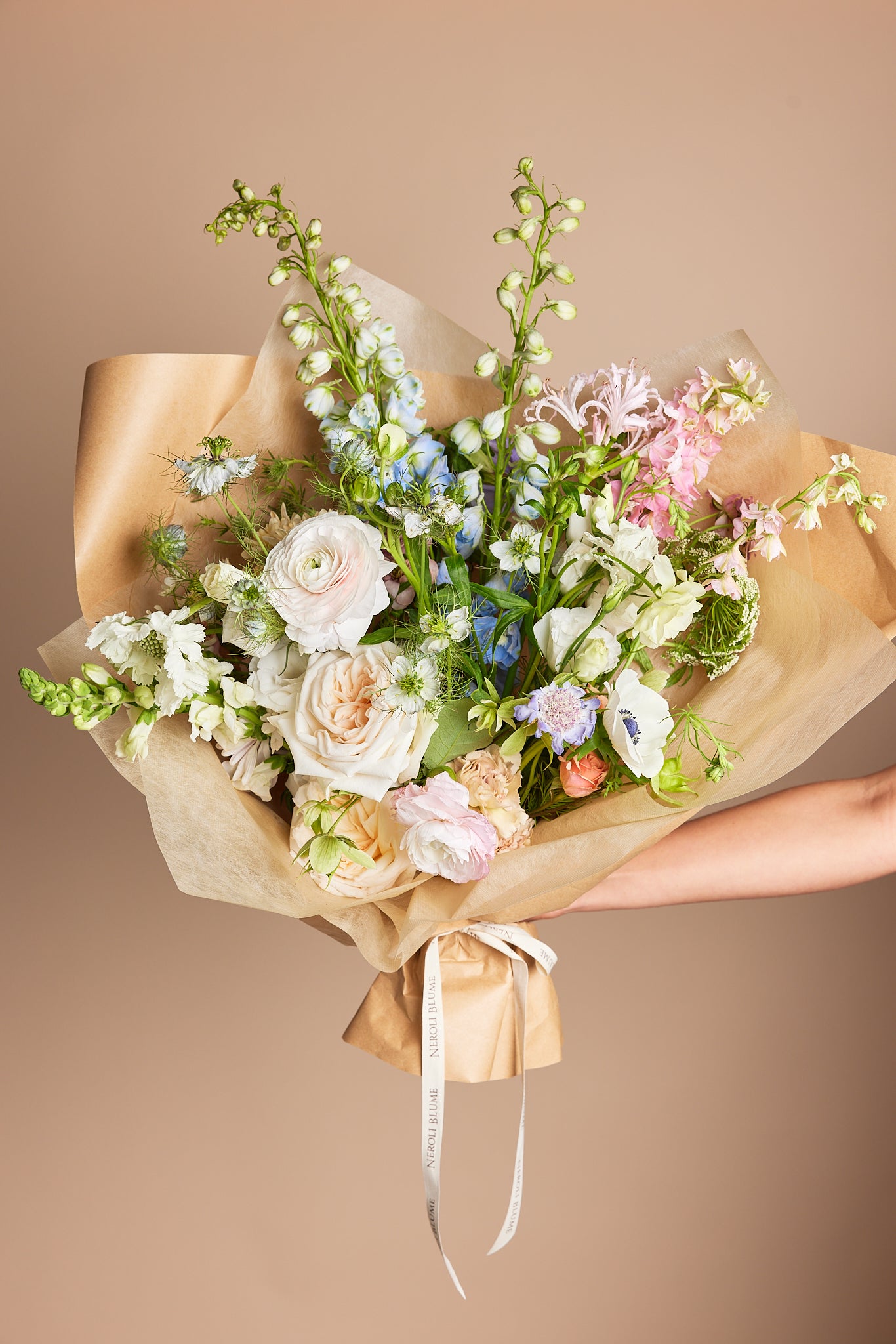 Hand-tied pastel bouquet in brown paper wrap
