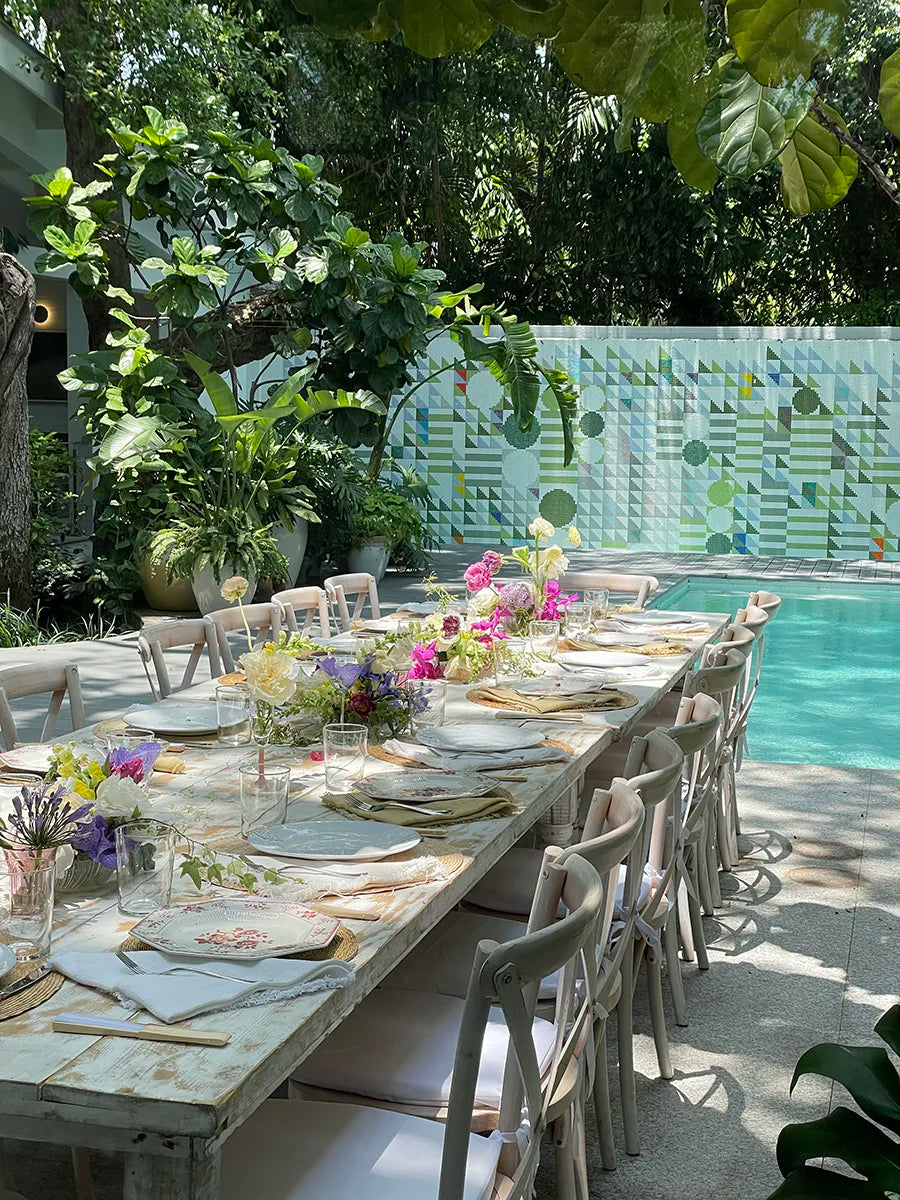 Poolside dining with rustic table and florals