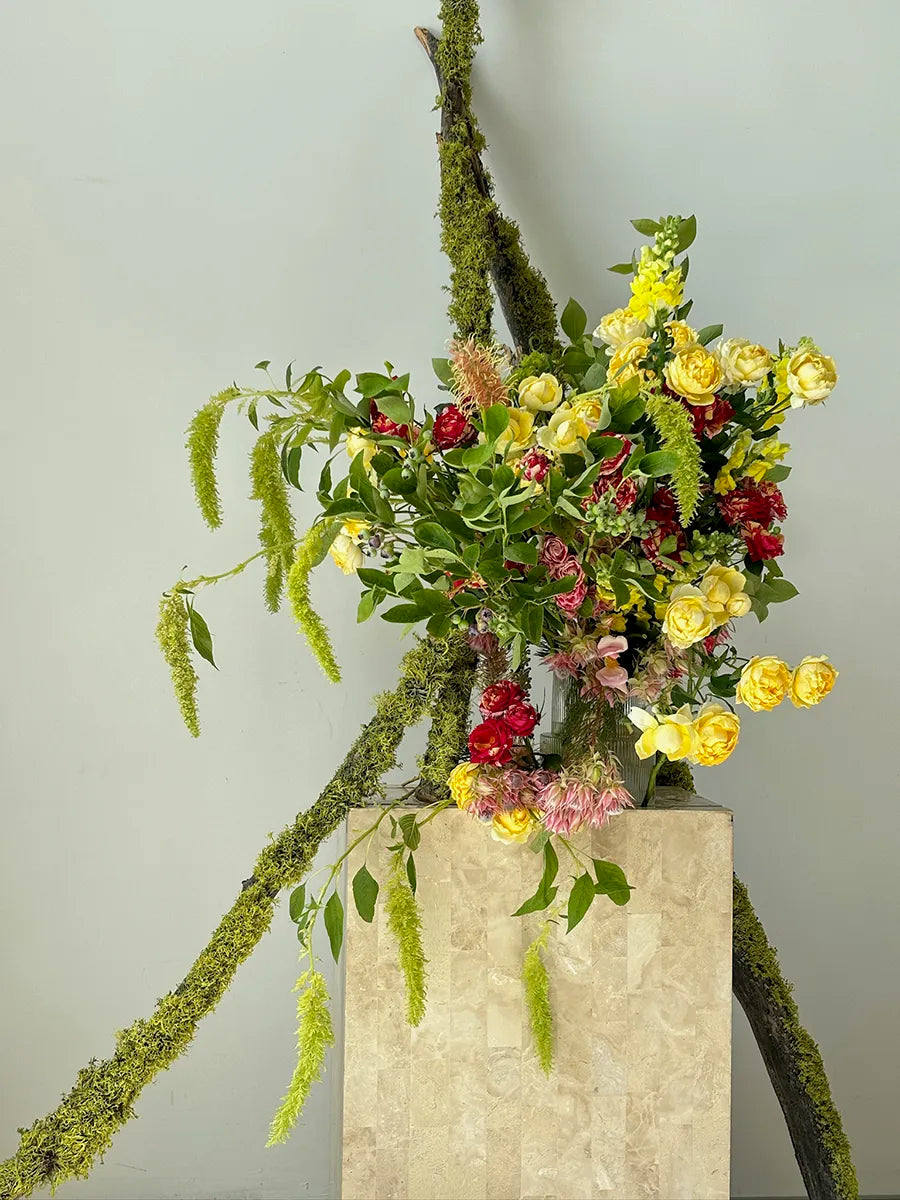 Lush yellow and red roses with cascading greenery