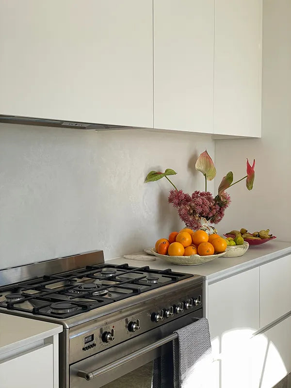 Modern kitchen with stove, fruits, and flowers
